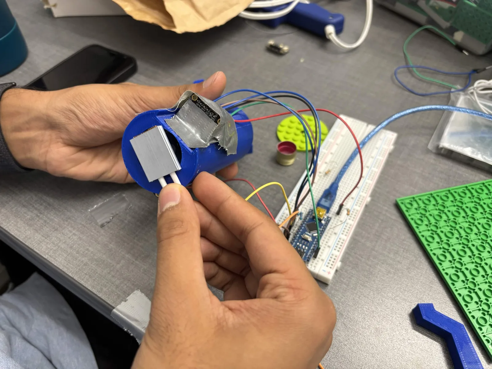 A hand-wired housing for the team's custom-built optical density sensor, late July 2026