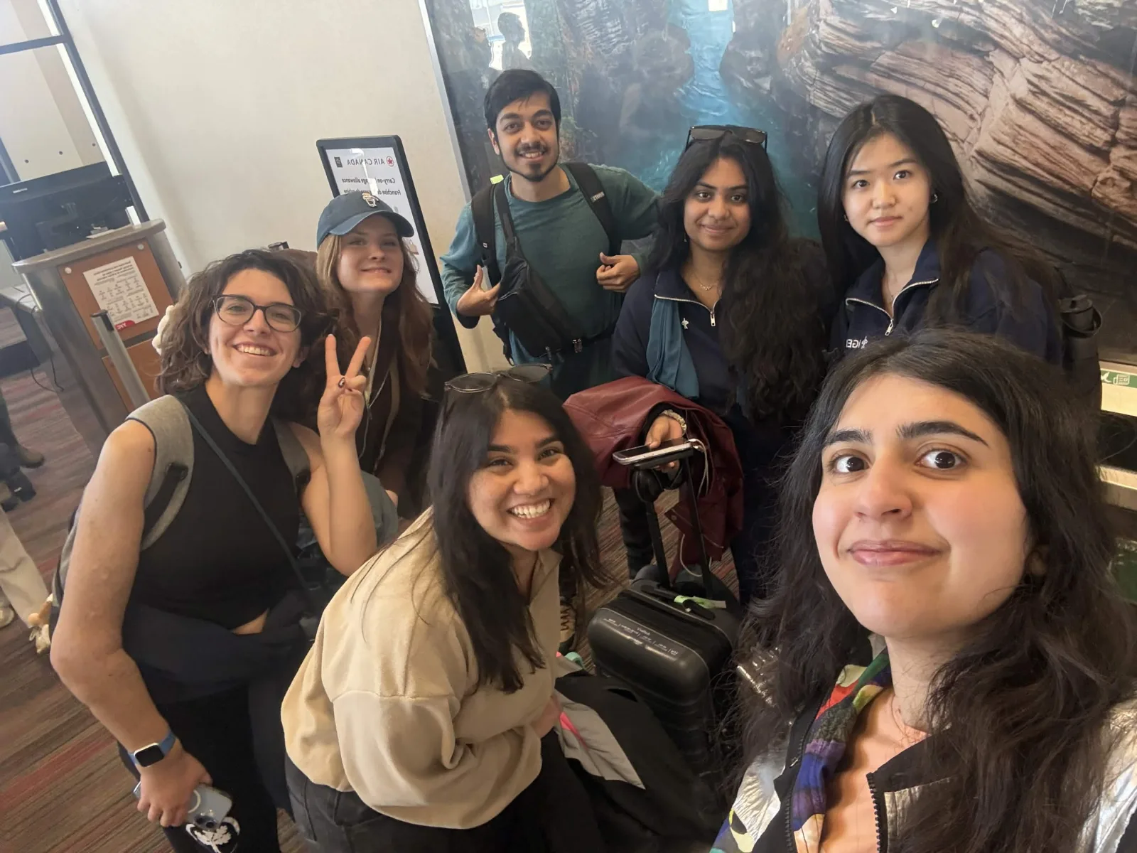 Team gathers with luggage at an airport gate before departure