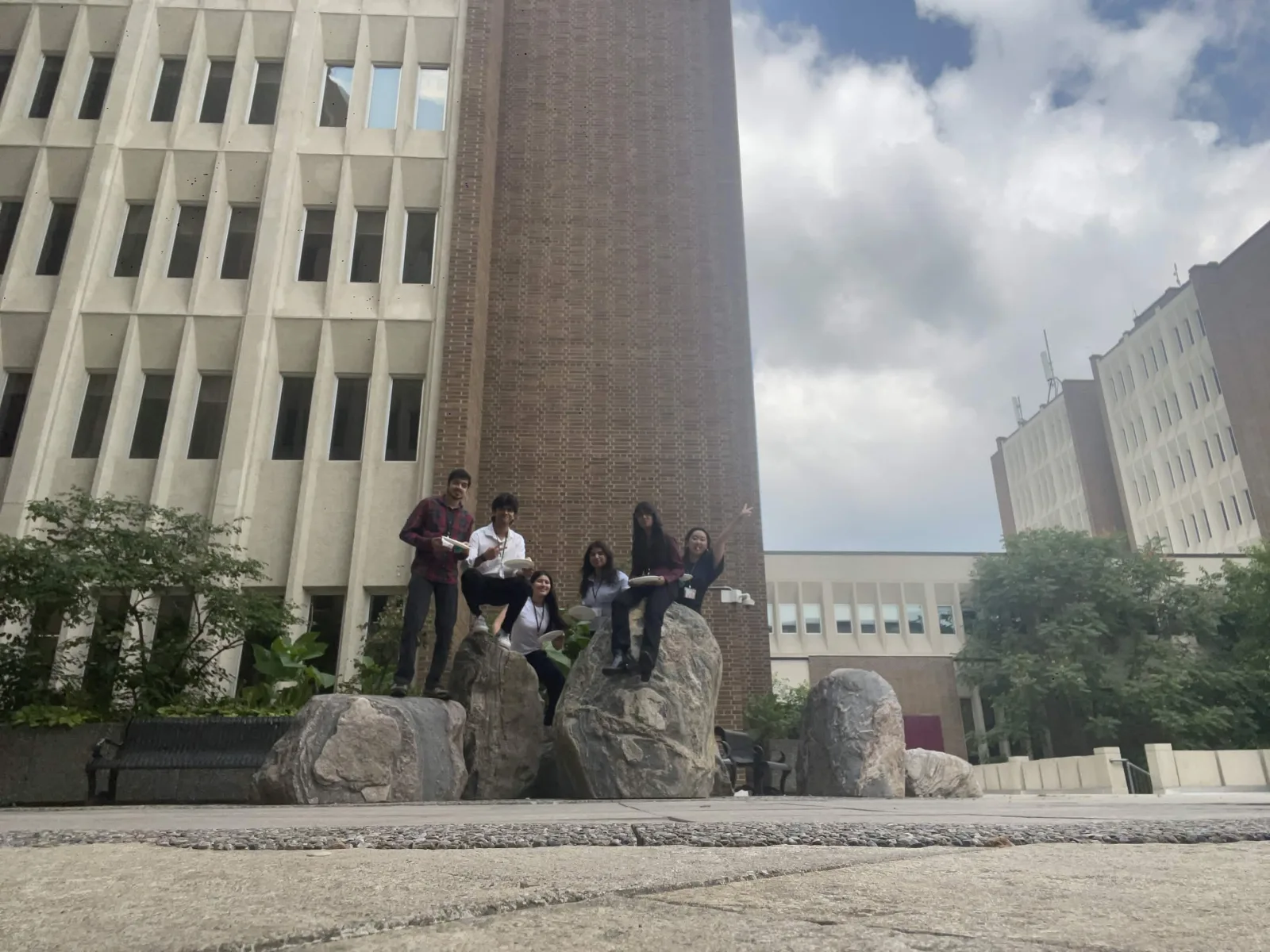 Team poses on campus boulders during a conference break, 08 August 2026.
