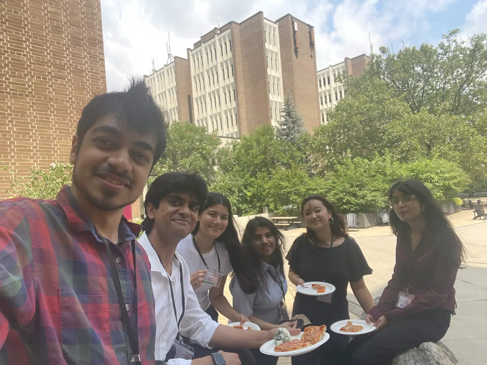 Conference break with pizza on a university campus quad, 08 August 2026.