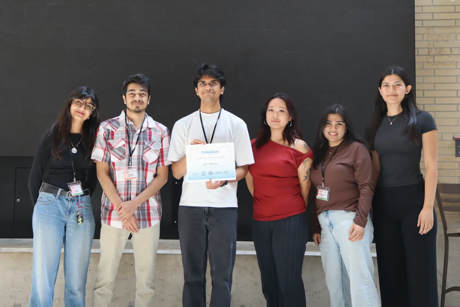 Team accepts its Great Canadian Meetup award, McMaster University, 8–9 August 2026 — second place overall, with Best Engineering Approach and Best Experimental Evidence