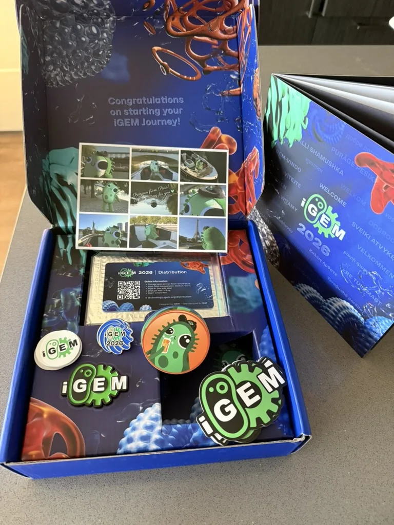 iGEM 2026 team distribution kit unboxed, 02 July 2026 — pins, stickers and welcome booklet.