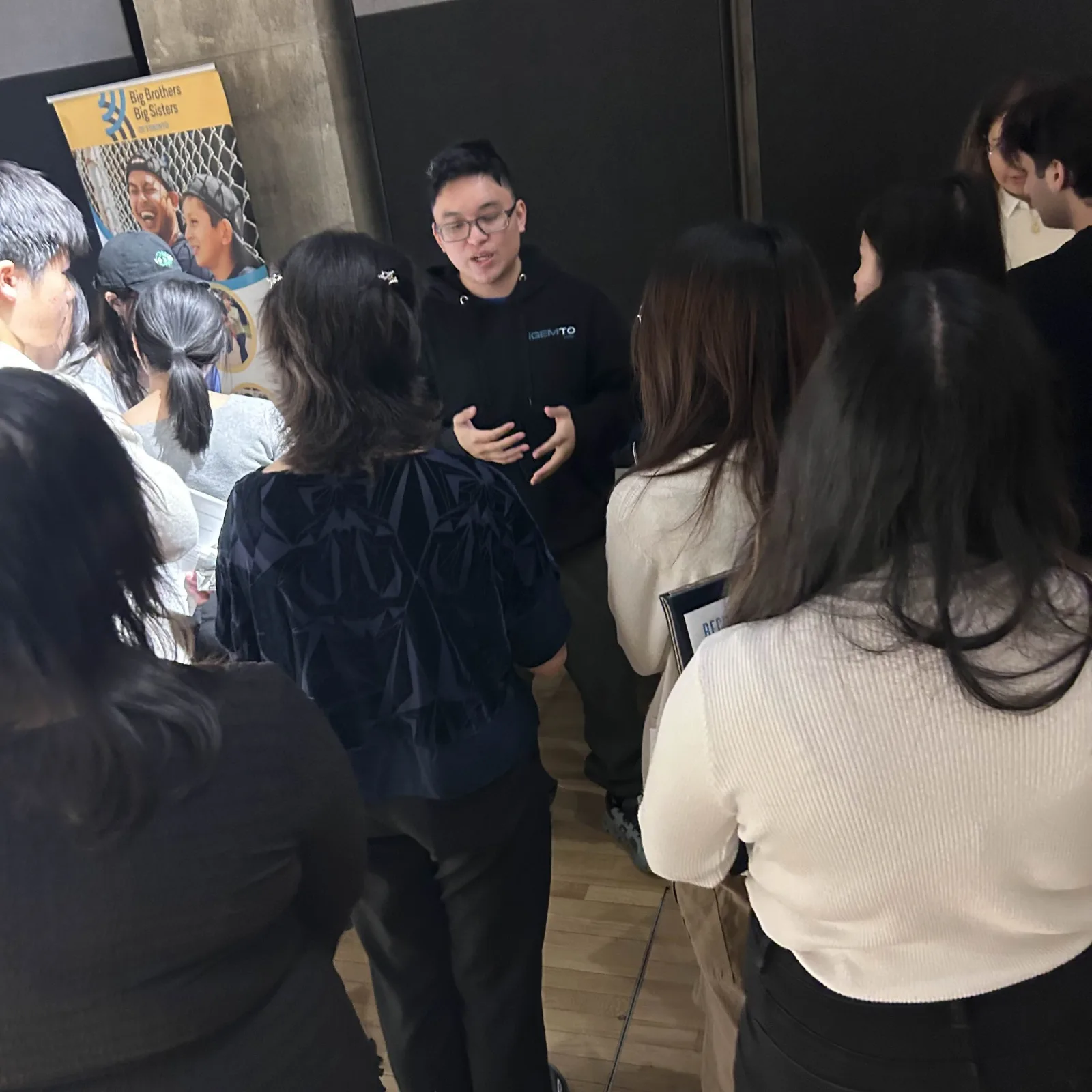 Team member discusses the project with visitors at a community fair, February 2026