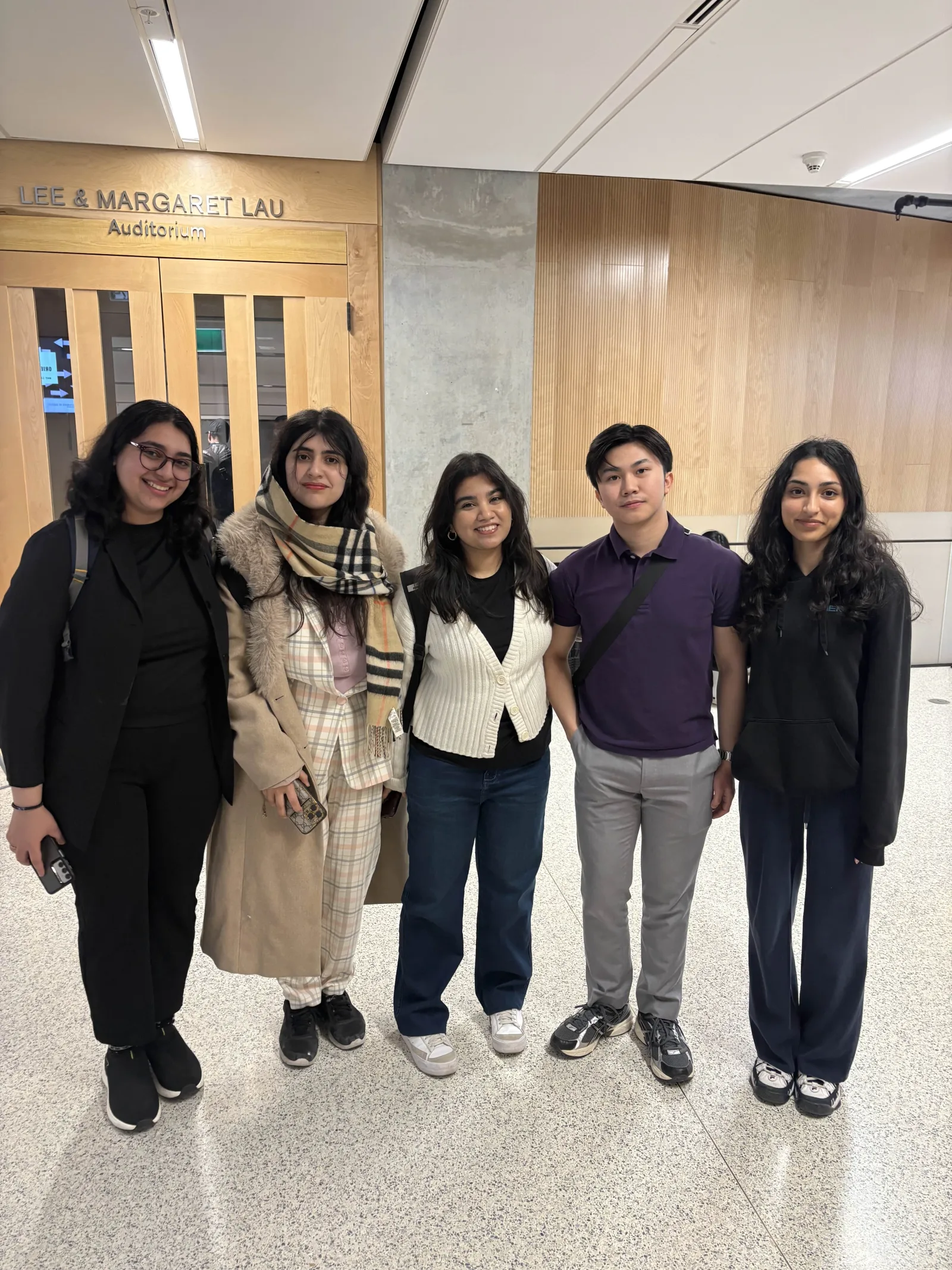 Team members outside the Lee and Margaret Lau Auditorium