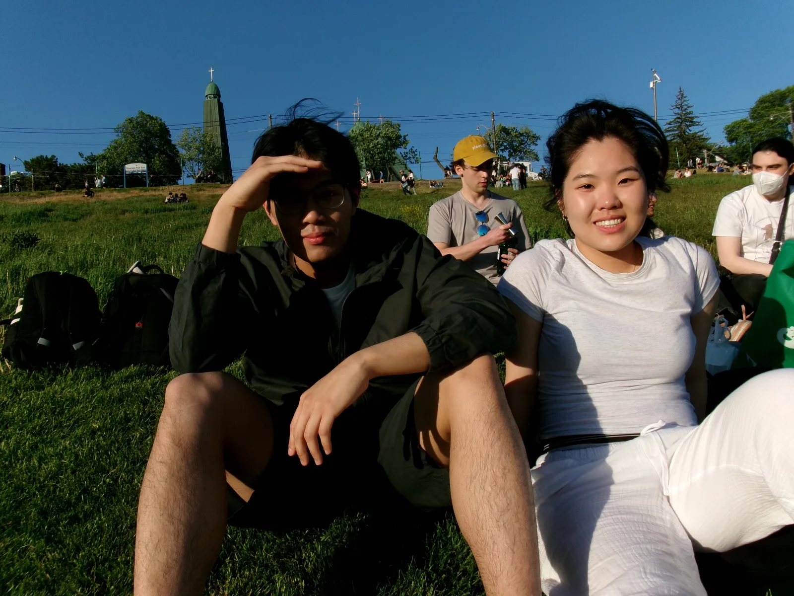 Two team members relax on the grass during an evening park outing