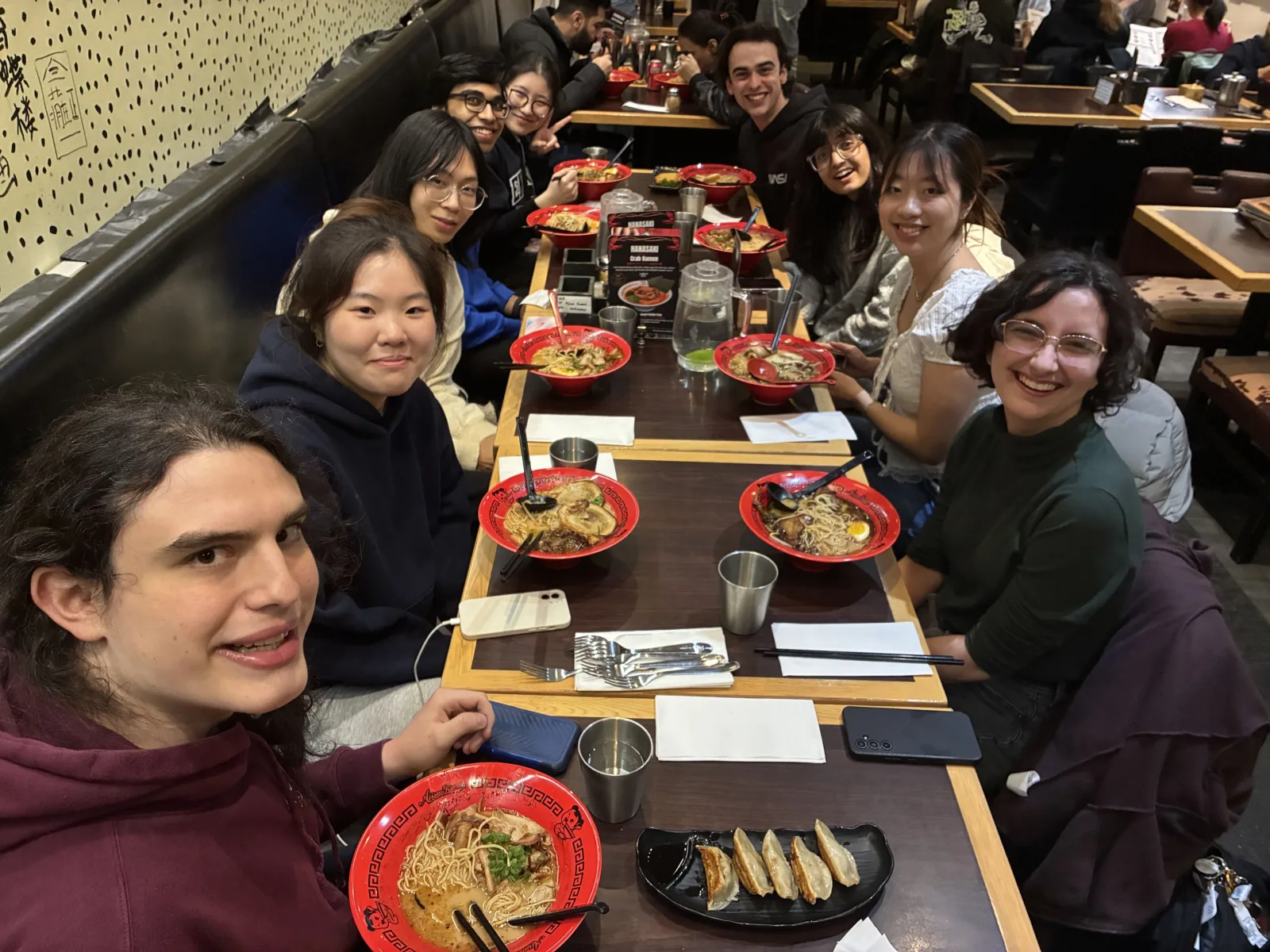 Group shares ramen bowls together at a team dinner, March 2026