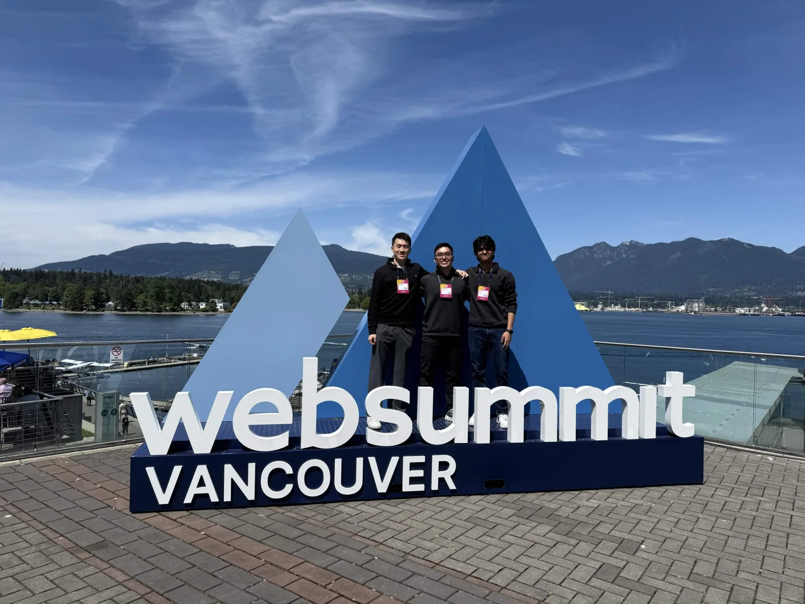 Team members pose at the Web Summit Vancouver sign